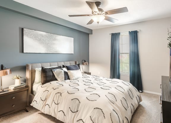 create a cozy bedroom with a comfy bed and ceiling fan at Parkwest Apartment Homes, Mississippi, 39402