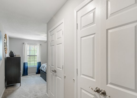 a bedroom with white closets and doors and a bed at Parkwest Apartment Homes, Hattiesburg