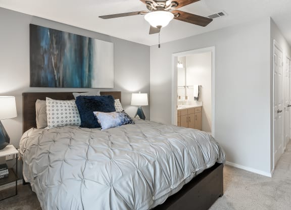 a bedroom with a large bed and a ceiling fan at Parkwest Apartment Homes, Hattiesburg, MS