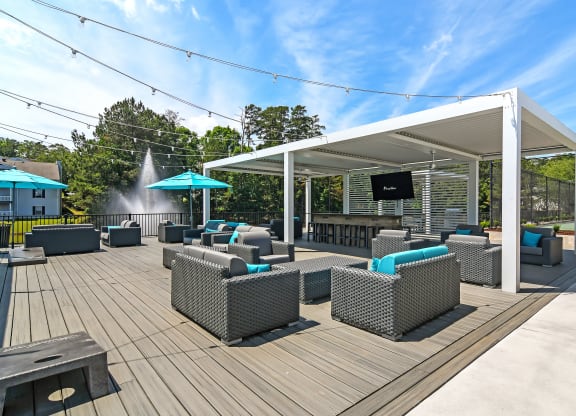 a rooftop deck with couches and chairs and a water fountain at The Woodlands Apartment Homes, Mississippi