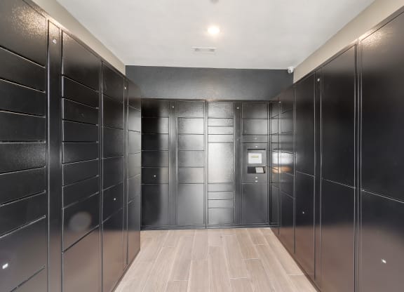 a row of black lockers in a room with wood floors at The Woodlands Apartment Homes, Meridian, 39301