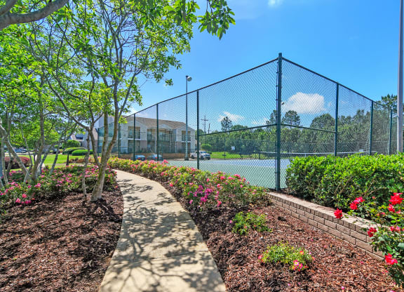 a path leading to a tennis court with a fence at Highpointe Apartment Homes, Brandon