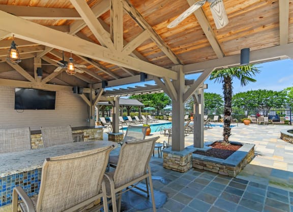 a resort style patio with a bar and a pool at Highpointe Apartment Homes, Mississippi