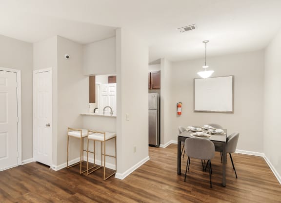 Dining room and kitchen with a table and chairs at Highpointe Apartment Homes, Brandon, Mississippi
