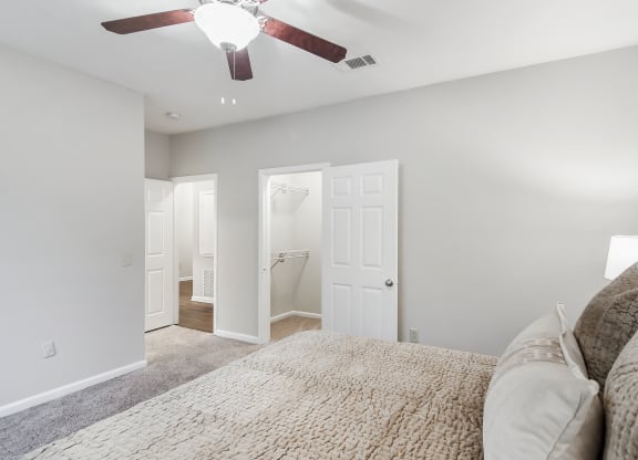 Bedroom with a large bed and a ceiling fan at Highpointe Apartment Homes, Brandon, MS, Mississippi