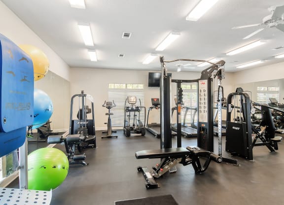 a fitness room with weights and other exercise equipment at Legacy Apartment Homes in MS 39157