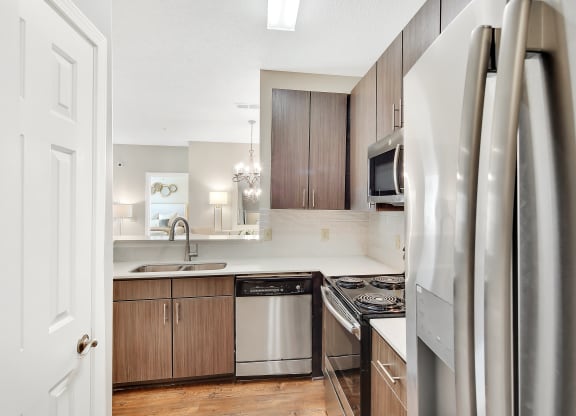 a kitchen with stainless steel appliances and wooden cabinets at Legacy Apartment Homes in Ridgeland, MS 39157