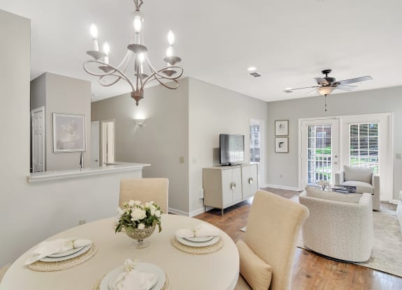 a dining room and living room with a table and chairs at Legacy Apartment Homes in MS 39157