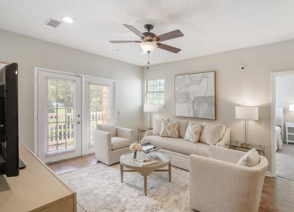 a living room with couches and chairs and a ceiling fan at Legacy Apartment Homes in Ridgeland, Mississippi 