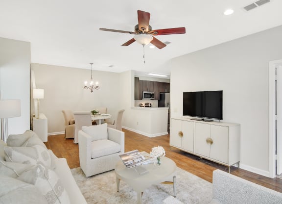 a living room with white furniture and a ceiling fan at Legacy Apartment Homes in Ridgeland, Mississippi 39157
