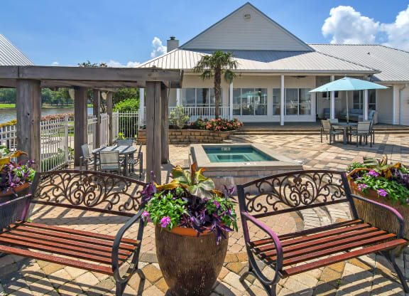 a patio with benches and a pool and a building at Lakeshore Pointe Apartment Homes, Brandon, 39047