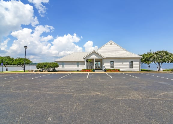 an empty parking lot in front of a white building at Lakeshore Pointe Apartment Homes, Mississippi