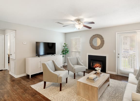 a living room with a fireplace and a ceiling fan at Lakeshore Pointe Apartment Homes, Brandon, 39047