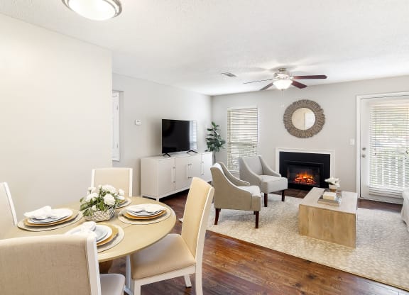 a living room and dining room with a table and chairs and a fireplace at Lakeshore Pointe Apartment Homes, Mississippi