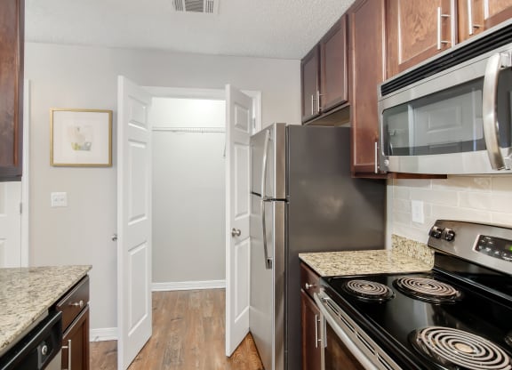 a kitchen with stainless steel appliances and granite counter tops at Lakeshore Pointe Apartment Homes, Brandon, MS, 39047