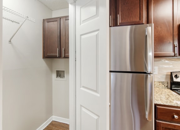 a kitchen with a stainless steel refrigerator and wooden cabinets at Lakeshore Pointe Apartment Homes, Brandon, MS