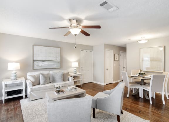an open living room and dining room with white furniture and a ceiling fan at Lakeshore Pointe Apartment Homes, Brandon, MS, 39047