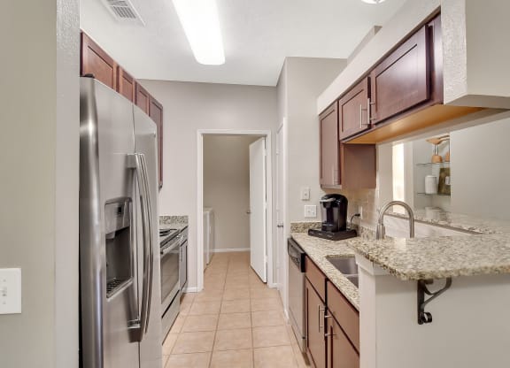 a kitchen with stainless steel appliances and granite counter tops at Ashford Place Apartment Homes, Flowood