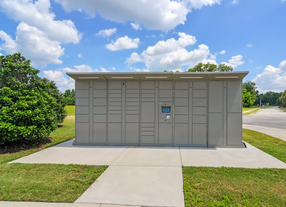 a small metal building with a garage door on the side of a sidewalk at Audubon Park Apartment Homes, Louisiana, 70791