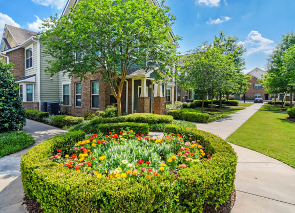 a flower garden in the middle of a sidewalk in front of some houses at Audubon Park Apartment Homes, Louisiana, 70791
