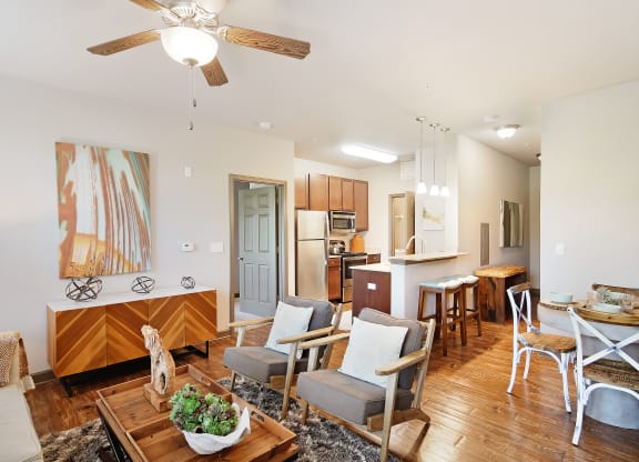 a living room with a dining room table and a kitchen at Audubon Park Apartment Homes, Louisiana