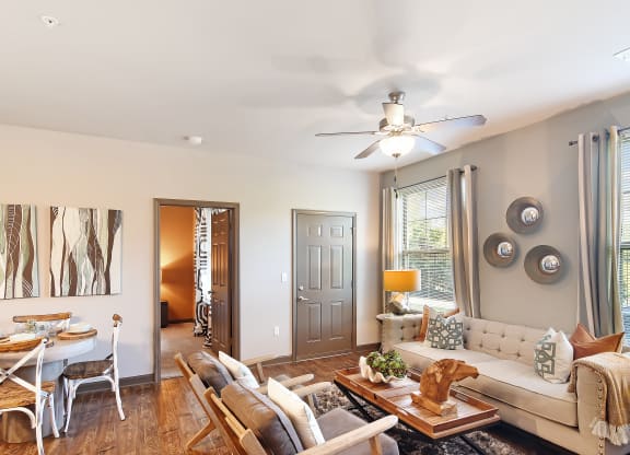 a living room with a couch and a table and a ceiling fan at Audubon Park Apartment Homes, Louisiana