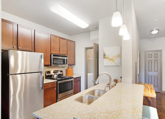 a kitchen with stainless steel appliances and a marble counter top at Audubon Park Apartment Homes, Zachary, 70791