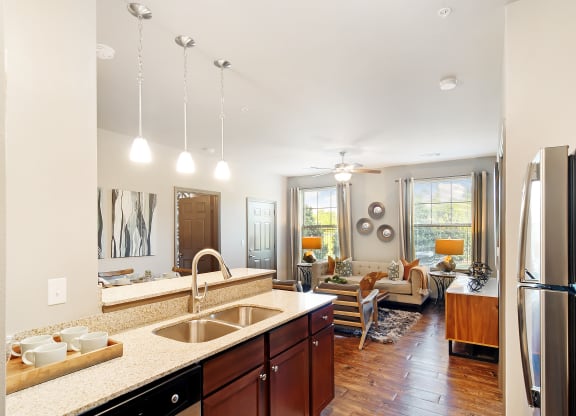 a kitchen and living room with a refrigerator and a sink at Audubon Park Apartment Homes, Louisiana