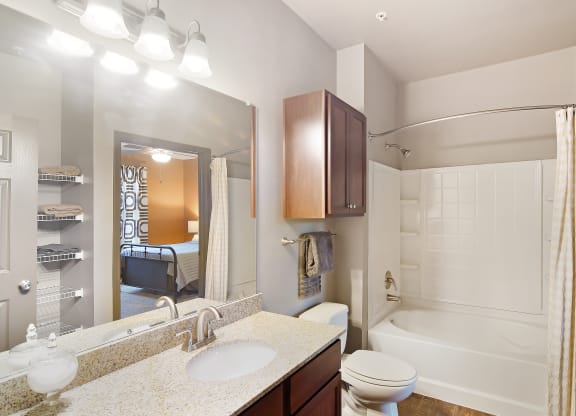 a bathroom with a shower toilet and sink and a mirror at Audubon Park Apartment Homes, Louisiana, 70791