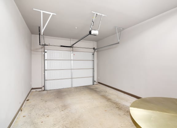 a white room with a table and a garage door at Audubon Park Apartment Homes, Louisiana, 70791