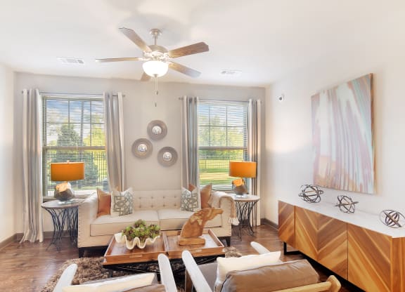 a living room with a ceiling fan and a couch at Audubon Park Apartment Homes, LA