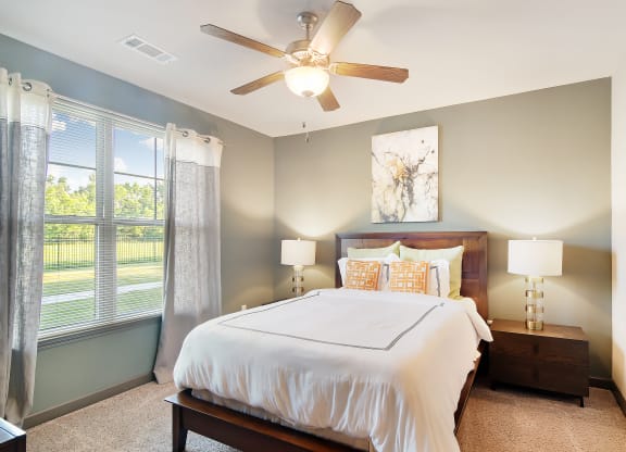 a bedroom with a large bed and a ceiling fan at Audubon Park Apartment Homes, Louisiana, 70791