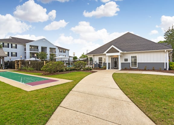 a house with a basketball court and a sidewalk at Avalon Apartment Homes, Starkville