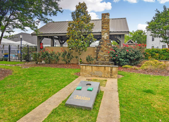 a park with a fountain and a house in the background at Avalon Apartment Homes, Starkville, 39759