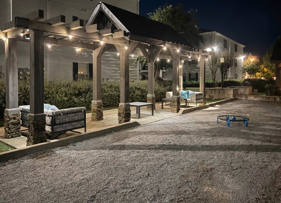 a patio with benches and lights on a house at night at Avalon Apartment Homes, Starkville, MS, 39759