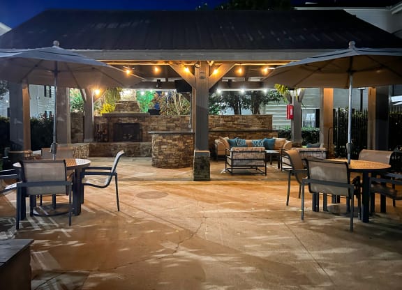 the patio of a restaurant with tables and umbrellas at Avalon Apartment Homes, Starkville, MS, 39759