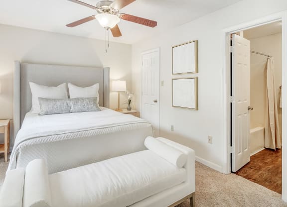 a bedroom with a large white bed and a ceiling fan at Cambridge Station Apartment Homes, Oxford, Mississippi