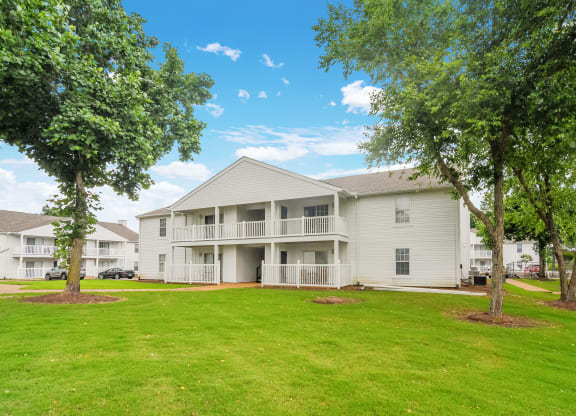 the outlook of a white apartment building with treesat The Plantation Apartment Homes, Mississippi, 38654