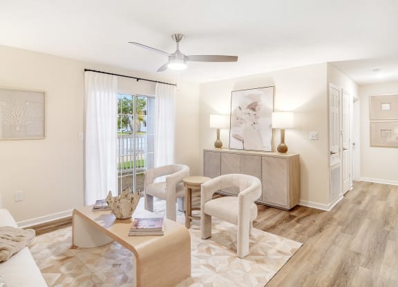a living room with a table and chairs and a ceiling fan at The Oliver Apartment Homes, Mississippi