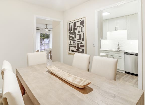 a dining room with a table and chairs and a kitchen at The Oliver Apartment Homes, Olive Branch, MS, 38654