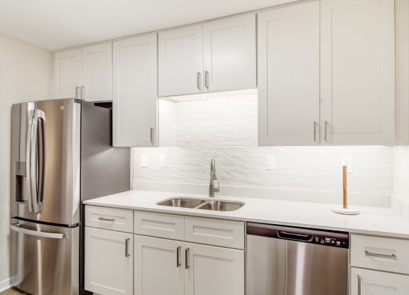 a white kitchen with stainless steel appliances and white cabinets at The Oliver Apartment Homes, Mississippi