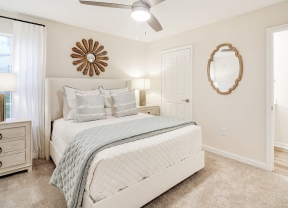 a bedroom with a white bed and a mirror at The Plantation Apartment Homes, Mississippi, 38654