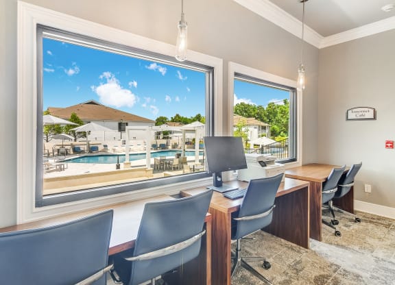 a conference room with a view of a pool and a desk with a computer at The Vineyard of Olive Branch Apartment Homes, Mississippi 38654