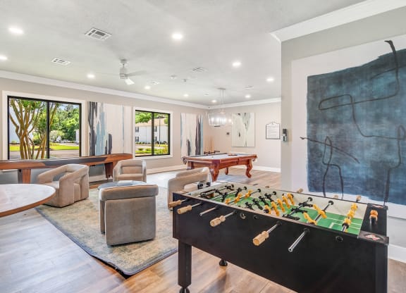 a game room with a foosball table and a pool table at The Vineyard of Olive Branch Apartment Homes, Olive Branch