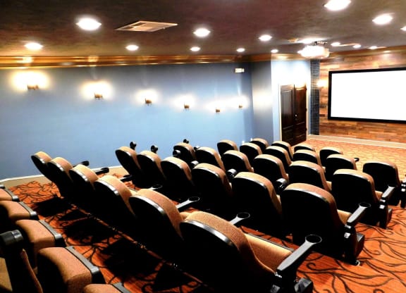 a conference room filled with chairs and a projector screen at Reserve at Gulf Hills Apartment Homes in Ocean Springs, Mississippi