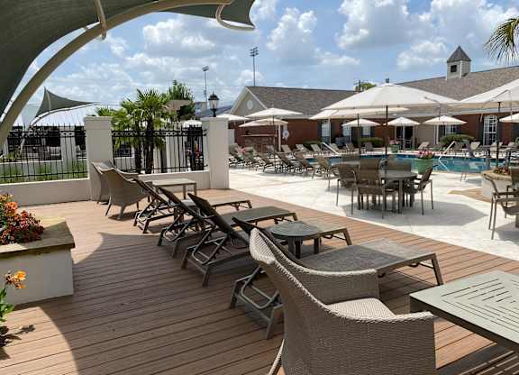 A poolside area with chairs and tables.
