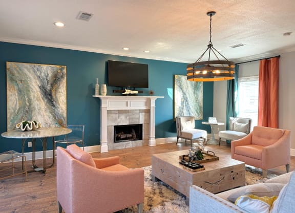 a living room with blue walls and a white fireplace at The Vineyard at Castlewoods Apartment Homes in Brandon, MS 