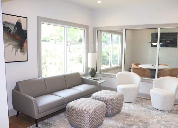 a living room with a couch and chairs and large windows at Reserve at Park Place Apartments, Hattiesburg, MS, 39402