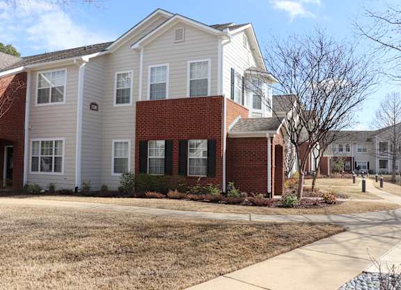 A residential building with a red brick section in the middle at Carlton Park Apartment Homes in Flowood, MS