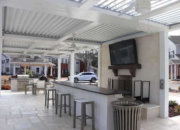 A patio with a bar and a television on the wall at Carlton Park Apartment Homes in Flowood, MS